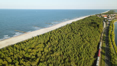 Aerial-Cinematic-view-on-road-between-green-forest-Baltic-Sea-and-guld-of-Gdansk,-Kuznica-Poland