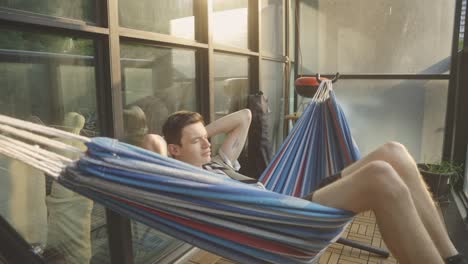 Man-Relaxing-In-Hammock-Indoors---close-up