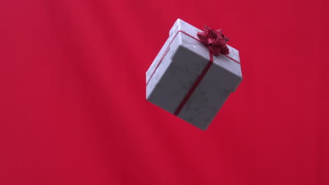 Regalo-De-Navidad-Cayendo-Sobre-Fondo-Rojo