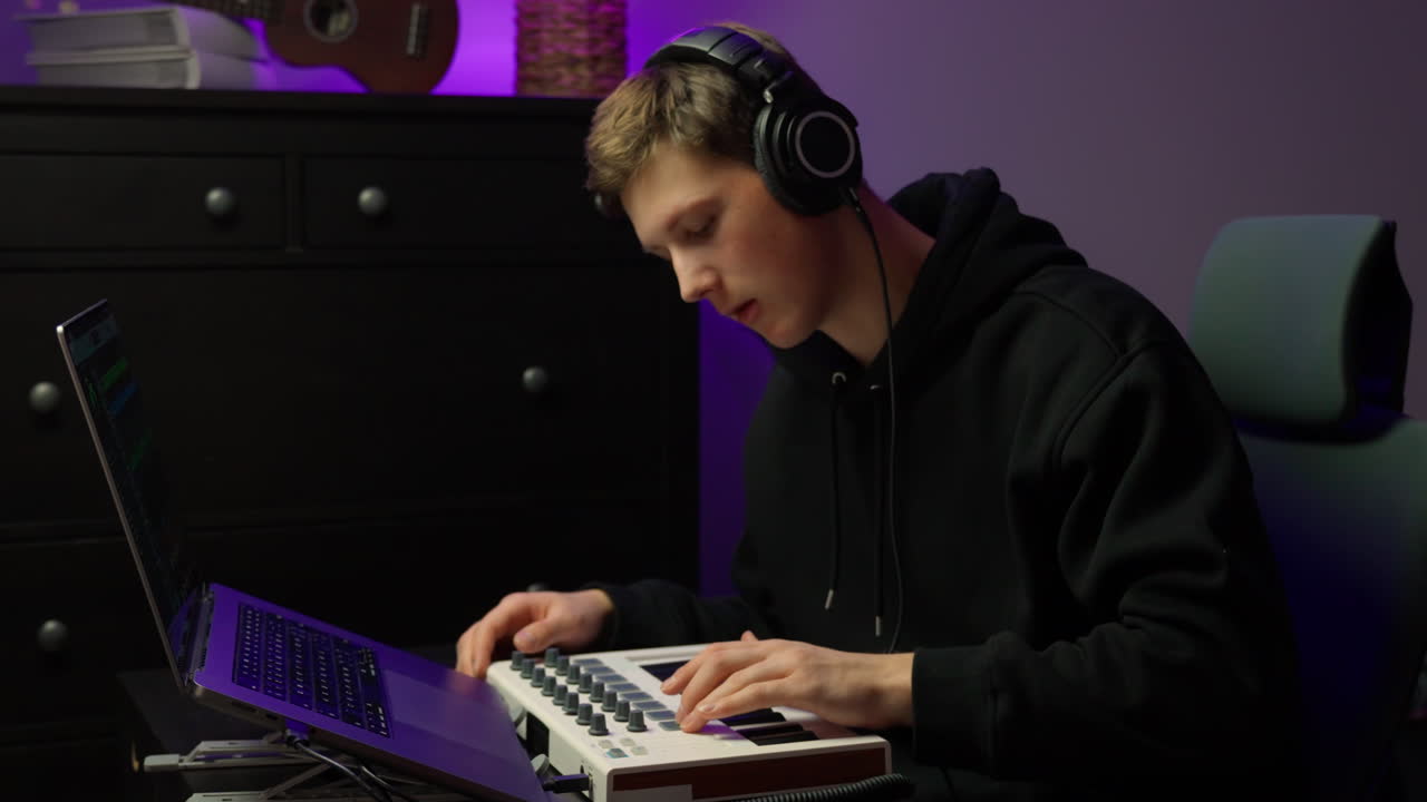 Giovane produttore musicale che crea beat su una tastiera MIDI, concentrato in uno studio domestico con cuffie, laptop moderno e illuminazione ambientale soffusa