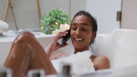 Mixed-race-woman-lying-in-a-bathtub-at-home