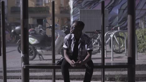 man using smartphone at bus stop