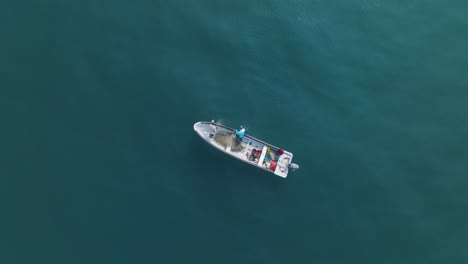 vista aérea de arriba hacia abajo en cámara lenta de un pequeño barco de pesca en el tunco el salvador