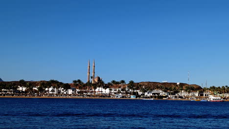 vista tranquila frente al mar de la mezquita sahaba en sharm el-sheikh bajo un cielo azul claro, toma estática