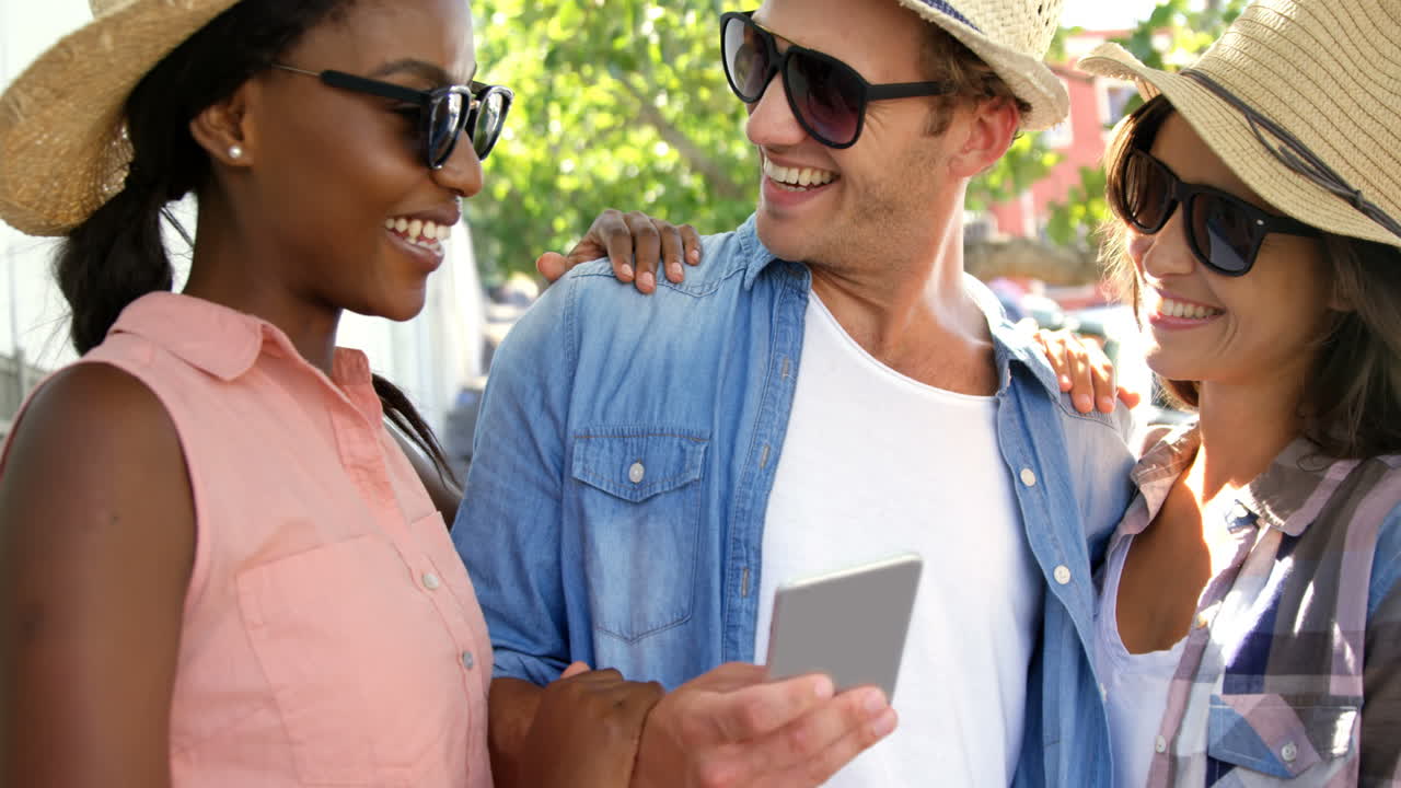 los jóvenes hipster están mirando un teléfono inteligente y riendo