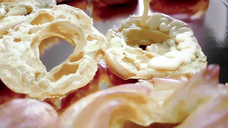 woman prepares delicious cream desserts called zeppole of st. joseph in a baking pan with a saccapoche, italian traditional religious event,  party of daddy, holiday is coming