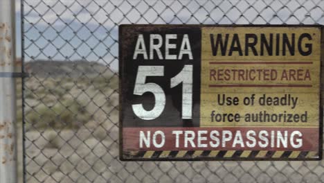 high quality 3d cgi render of a chainlink fence at a secret military installation in a desert scene, with an area 51 warning restricted area sign