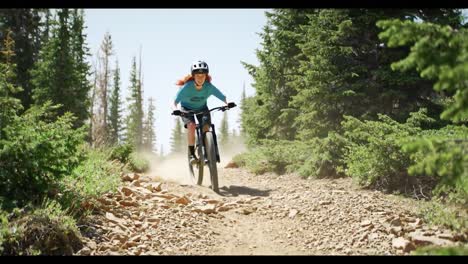 woman mountain biking on a sunny trail
