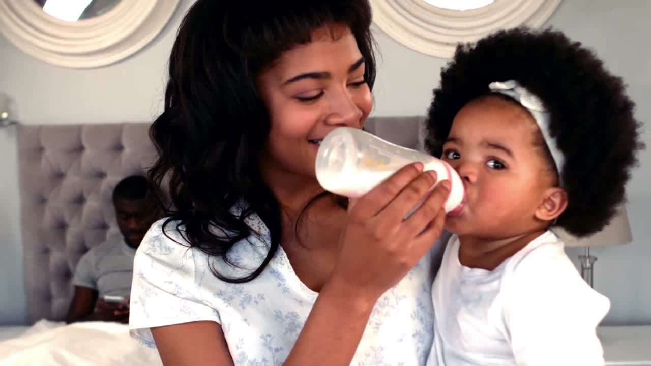 madre sonriente alimentando a su bebé