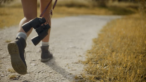 mujer con binoculares caminando por la pasarela