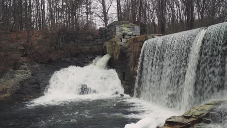 water rushes over a 19th century dam in massachusetts