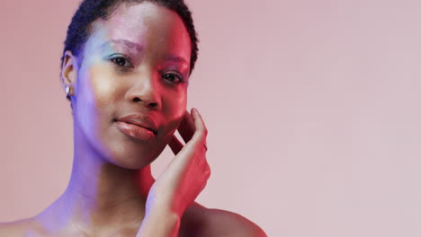mujer afroamericana con cabello oscuro corto en luz azul y rosa con espacio de copia, cámara lenta