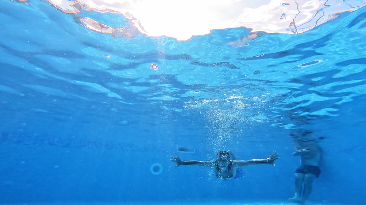 Underwater fun. Handsome young man swimming in pool. Sport and leisure.
