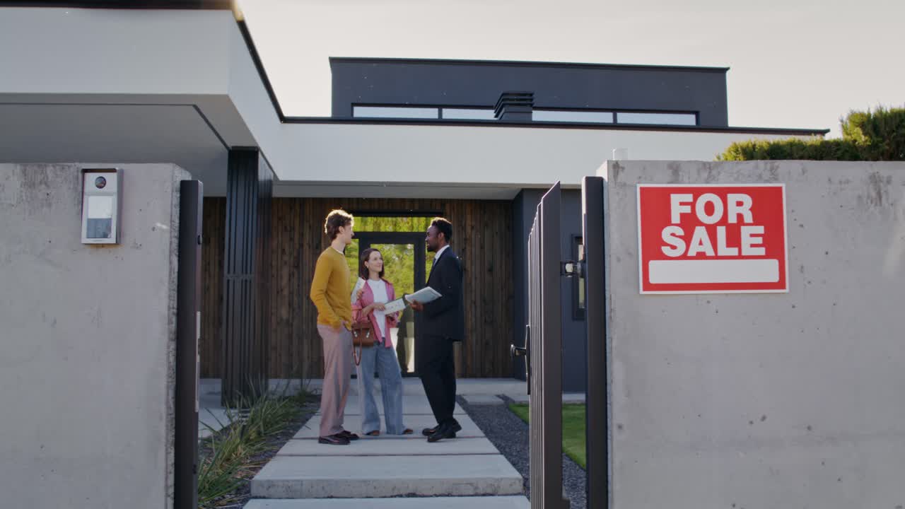 Potenziali acquirenti che incontrano un agente immobiliare davanti a una casa moderna