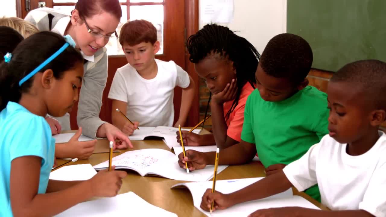 maestra hablando con sus alumnos entusiastas escribiendo en blocs de notas