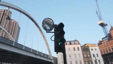 London-traffic-light-turning-green-amber-red-cars-moving-in-mirror-reflection