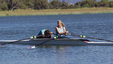 two senior caucasian women in rowing boat resting