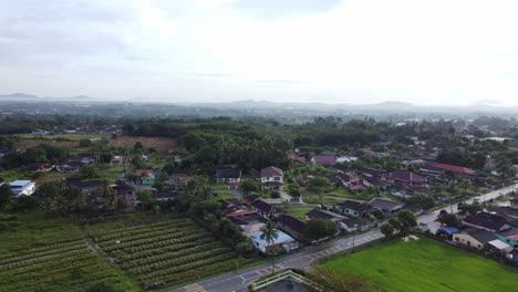 Cacerolas-Alrededor-De-Casas-De-Pueblo-Al-Mediodía-En-Melaka-Malasia-Con-Valles-Más-Allá-Del-Ligero-Horizonte-Brumoso