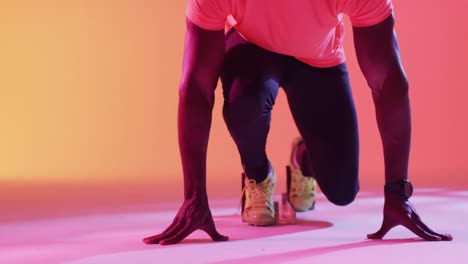 video of midsection of african american male runner preparing for start on neon orange lightning