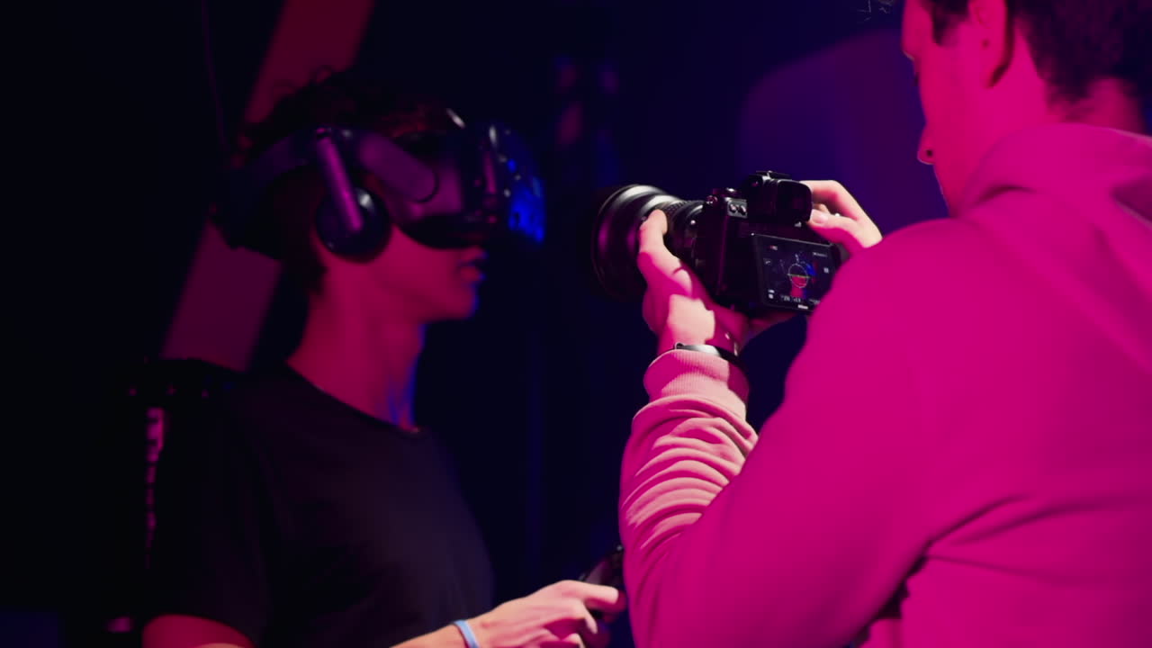 Operatore alla telecamera che riprende un ragazzo che gioca con un visore per la realtà virtuale in uno studio
