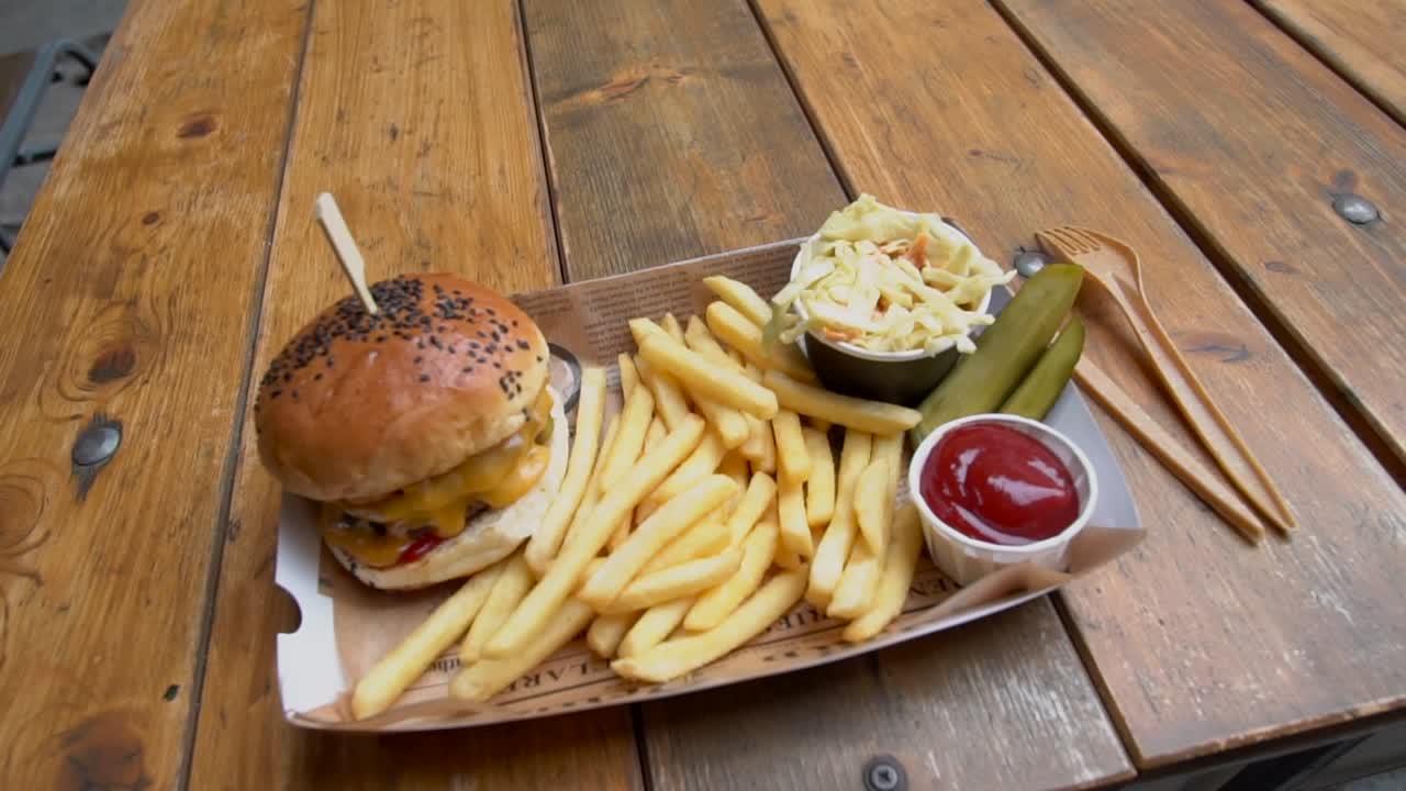 hamburguesa de jamón servida con papas fritas y mayonesa, aislada en el fondo de una mesa de madera