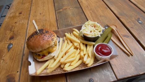 Hamburguesa-De-Jamón-Servida-Con-Papas-Fritas-Y-Mayonesa,-Aislada-En-El-Fondo-De-Una-Mesa-De-Madera