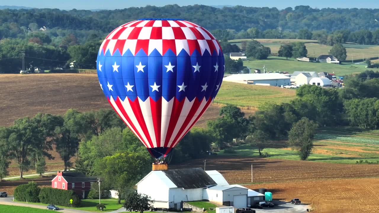 Mongolfiera con bandiera americana decolla durante un festival di mongolfiere nella contea di Lancaster, Pennsylvania, USA.