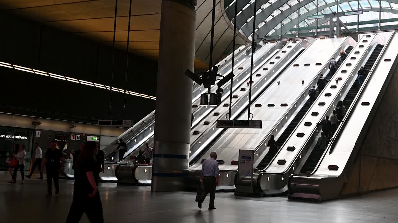 People using long escalators in a modern subway or train station