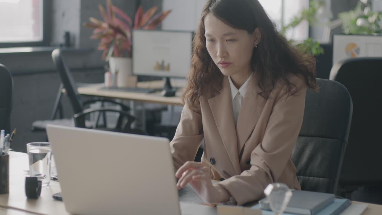 オフィスでラップトップで働く女性