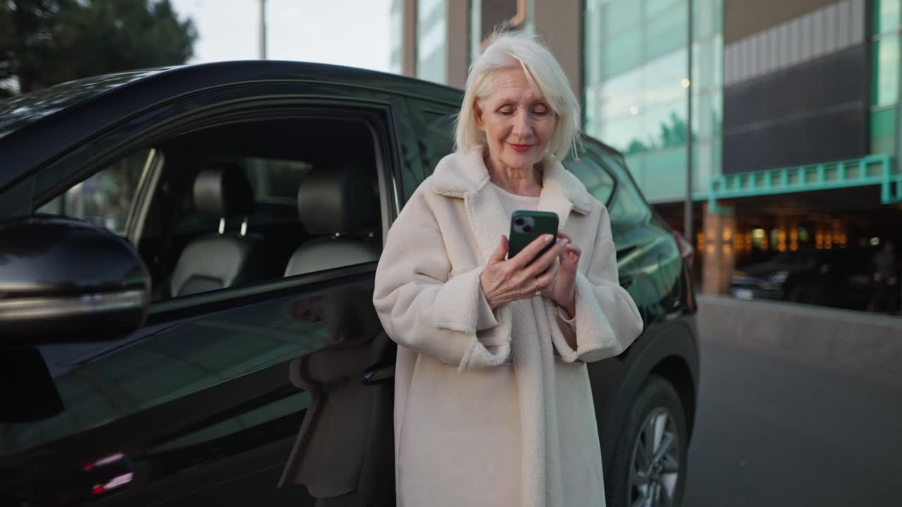 Senior Woman Using Cellphone by Car