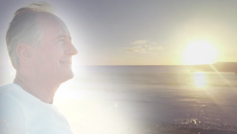 Animation-of-glowing-light-over-happy-senior-man-by-seaside