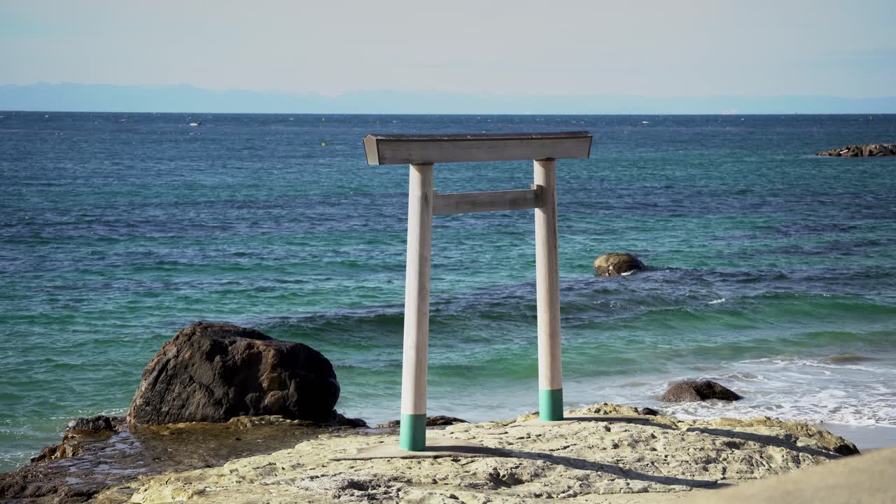 Una vista rilassante del portale Torii shintoista vicino alle acque blu dell'oceano
