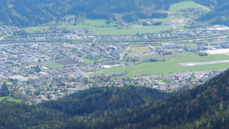 Aircraft-Lands-at-Innsbruck-Airport,-High-Angle-View-From-the-Mountain