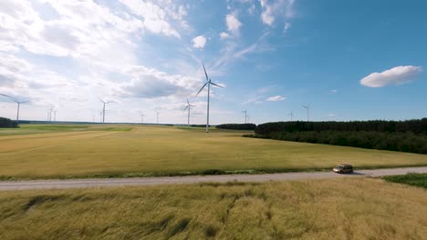 FPV-aerial-view:-wind-turbines-on-a-sunny-day