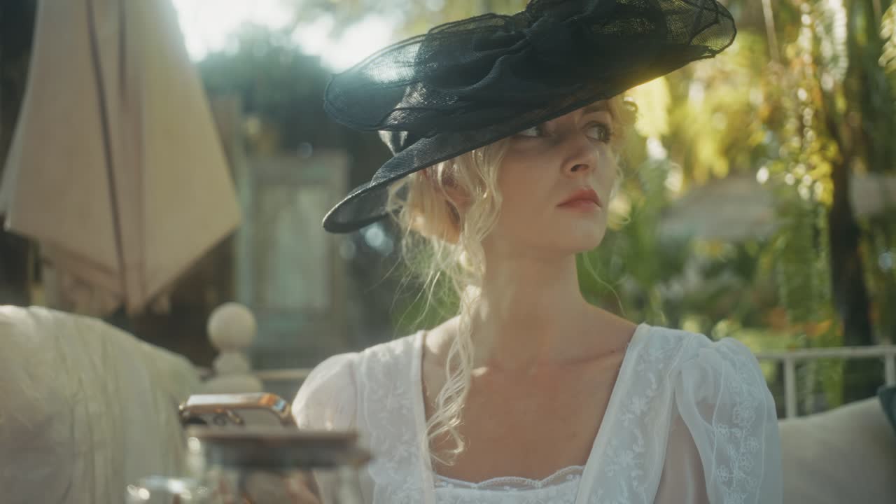Donna elegante con cappello vintage che utilizza lo smartphone all'aperto