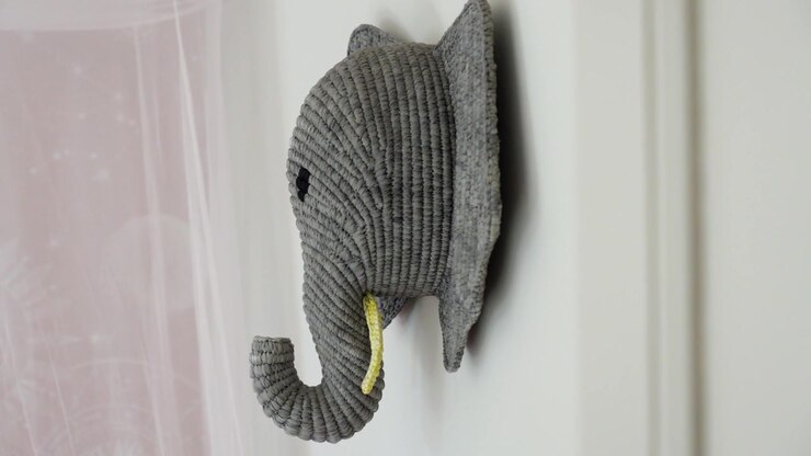 Decorazione murale a forma di testa di elefante intrecciata grigia esposta in un moderno interno di casa a La Rochelle