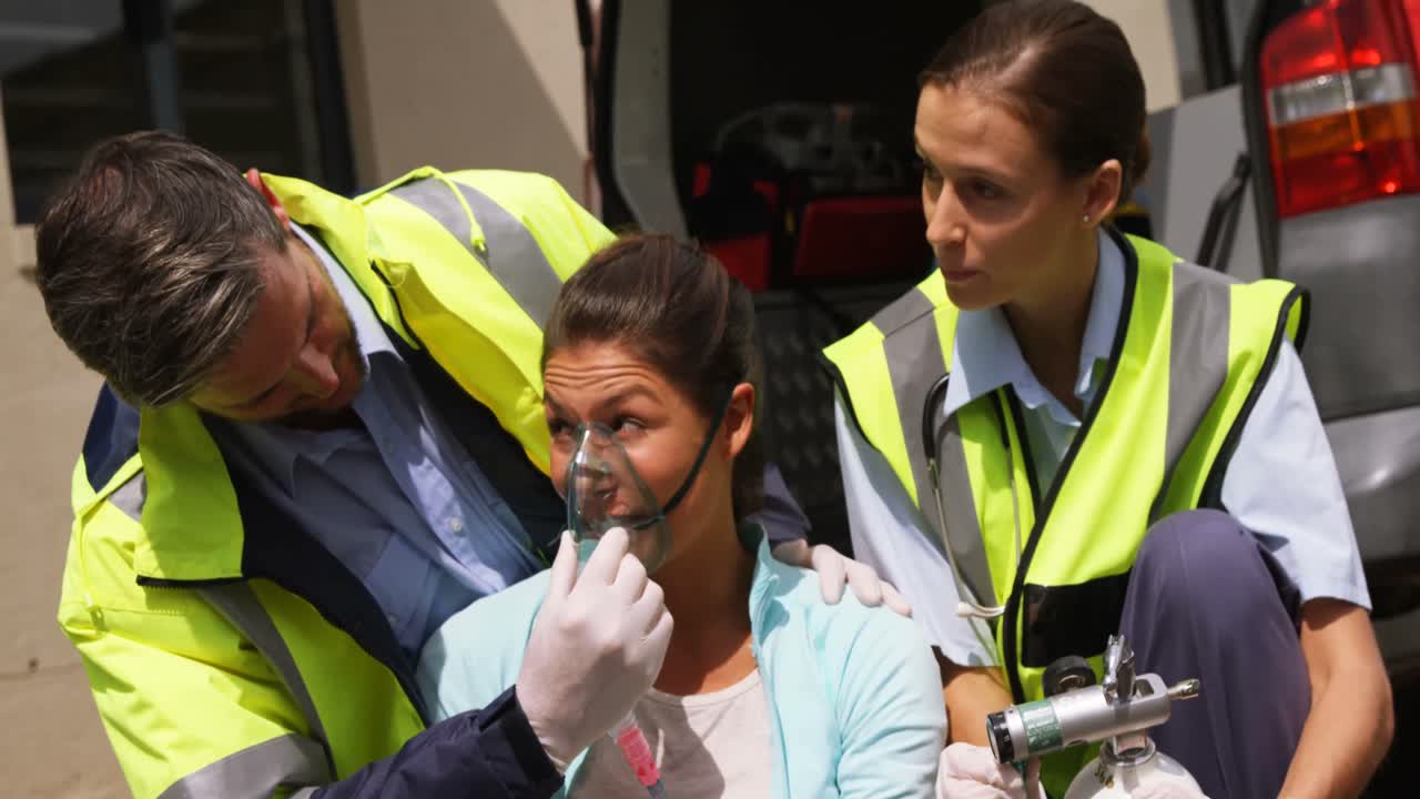 Patient receiving oxygen mask from ambulance team
