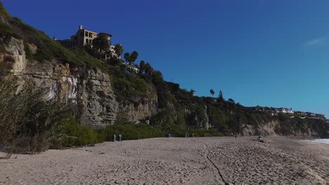 Exuberante-Acantilado-Con-Playa-Vacía-Y-Red-De-Voleibol