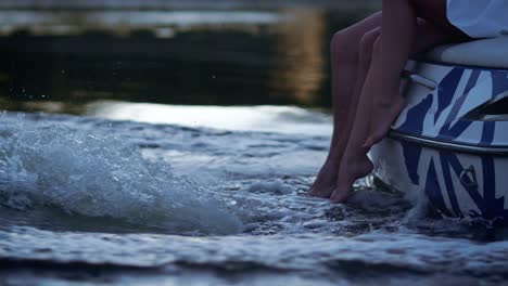 Menschliche-Beine-Im-Schäumenden-Wasserfluss.-Liebespaar-Fährt-Abends-Auf-Dem-Fluss-Boot.