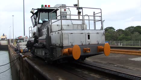 dos locomotoras tirando lentamente del barco en la cámara de esclusas de gatun, canal de panamá