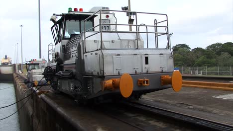 two locomotives slowly pulling the ship in the gatun locks chamber, panama canal