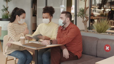 diverse friends in masks in cafe