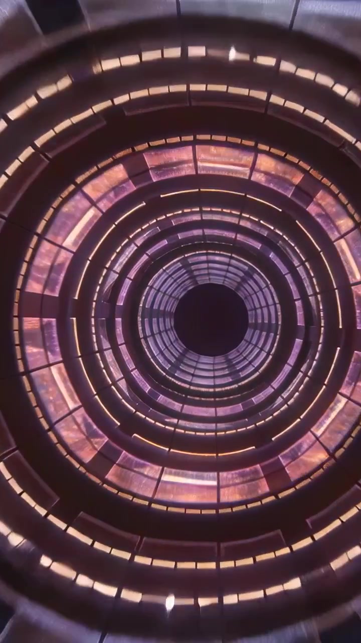Video verticale: Telecamera che si inclina verso l'alto e mette a fuoco un lucernario nella hall, con anelli e riflessi LED.