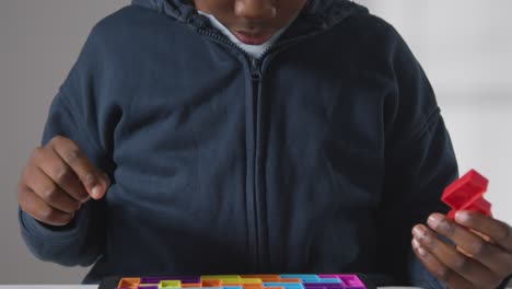 Close-Up-Of-Boy-On-ASD-Spectrum-Solving-Shape-Puzzle-On-White-Background-1