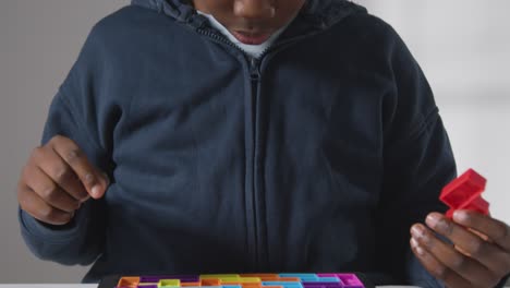 primer plano de niño en el espectro asd resolviendo rompecabezas de forma sobre fondo blanco 1