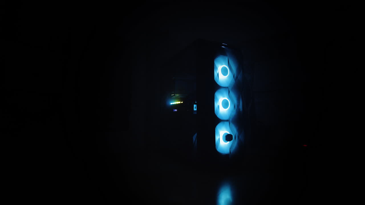 primer plano cinematográfico de un escritorio de pc moderno, con luces led alternantes en una habitación oscura