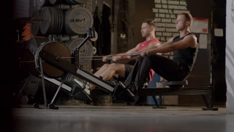 men exercising on rowing machines in a gym