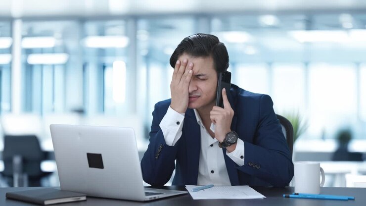 un manager indiano stressato che parla al telefono.