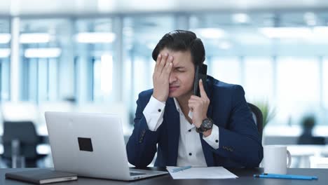 stressed indian manager talking on phone