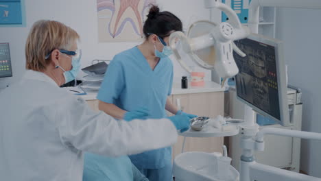 dentistry team performing tooth extraction in stomatology cabinet